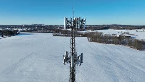 Cell-tower-in-rural-American-with-snow-covered-countryside-landscape