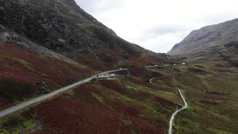 Aerial-decending-shot-of-the-A82-road-passing-through-the-Gencoe-Mountains-Scotland-UK