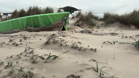 Fishing-vessels-rest-on-the-sandy-shore,-revealing-a-picturesque-seascape,-with-waves-crashing-against-the-coastline