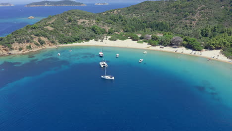 Aéreo:-Veleros-Y-Catamaranes-En-La-Playa-De-La-Isla-Tsougria-Cerca-De-Skiathos,-Esporadas,-Grecia