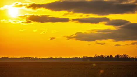 Wunderschöner-Sonnenaufgang-Im-Zeitraffer-In-Lettland,-Atemberaubende-Orangetöne-über-Der-Wiese