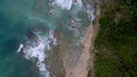 Top-down-drone-view-of-rocky-coastline-near-Australia's-Great-Ocean-Road-with-waves-and-turquoise-water