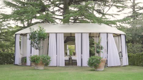 established-of-gazebo-open-structure-with-set-table-ready-for-wedding-ceremony-lunch-under-a-forest-pine-tree