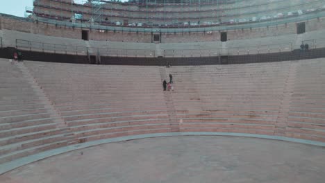 Girando-Alrededor-De-Las-Gradas-De-Piedra-De-Un-Antiguo-Teatro,-Con-Un-Magnífico-Resplandor-Del-Sol