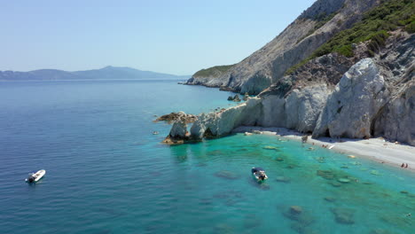 Aerial:-Slow-panning-drone-shot-of-Lalaria-beach-in-Skiathos-island,-Sporades,-Greece-with-turquoise-and-emerald-crystal-clear-water