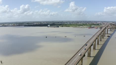 Toma-Aérea-De-Gran-Angular-Del-Puente-Jules-Wijdenbosch-Entre-Paramaribo-Y-Meerzorg-En-Surinam,-Sudamérica,-Con-Tráfico-A-Medida-Que-Los-Drones-Avanzan-Hacia-Atrás.