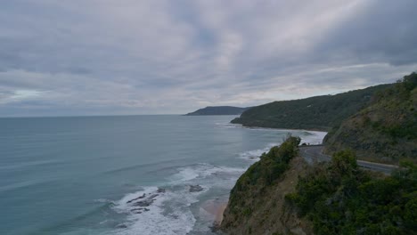 Los-Coches-Circulan-Por-La-Gran-Curva-Del-Acantilado-De-La-Carretera-Oceánica-En-Un-Día-Nublado-Y-Nublado-En-Victoria,-Australia