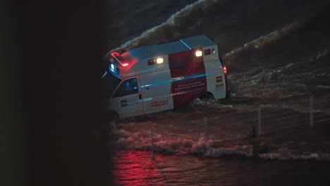 El-16-De-Abril-De-2024,-Una-Ambulancia-Navegó-Bajo-La-Lluvia-En-Una-Carretera-Inundada-En-Sharjah,-Emiratos-Árabes-Unidos.