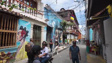 Gente-Caminando-Junto-A-Coloridas-Pinturas-Murales-En-El-Barrio-Getsemani-En-Cartagena,-Colombia