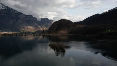 Vista-Panorámica-Aérea-De-La-Cordillera-De-Colinas-Y-Alpes-Al-Fondo-En-Walensee,-Suiza