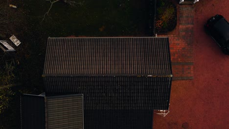 Drone-De-Arriba-Hacia-Abajo-Disparado-Sobre-Un-Musgo-En-El-Techo-De-Un-Garaje,-Día-De-Otoño-En-Una-Casa-De-Campo