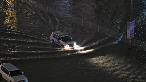 El-16-De-Abril-De-2024,-Un-Vehículo-De-Rescate-Navega-Bajo-La-Lluvia-En-Una-Carretera-Inundada-Por-La-Noche-En-Sharjah,-Emiratos-Árabes-Unidos,-Después-De-Que-Lluvias-Sin-Precedentes-Azotaran-El-País.