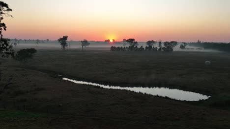 Drohnenaufnahme-Eines-Aufstiegs-über-Einem-Teich-Bei-Sonnenaufgang