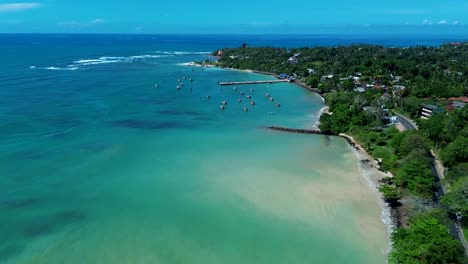 Aerial-drone-landscape-coastline-view-of-Weligama-bay-with-wharf-boats-docked-around-sandbar-Indian-Ocean-Sri-Lanka-travel-holidays-tourism
