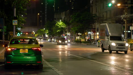 Taxis-Und-Andere-Fahrzeuge-Parken-Am-Straßenrand-In-Der-Nähe-Einer-Ampel-Und-Einem-Fußgängerüberweg-Auf-Einer-Der-Hauptverkehrsstraßen-In-Bangkok,-Thailand