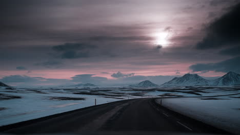 POV-driving-video-through-Northern-Iceland's-snowy-landscape-at-sunset,-capturing-serene-winter-beauty-and-soft-lighting