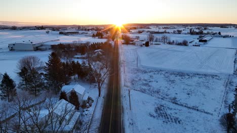 Golden-hour-sunrise-over-snow-covered-landscape-in-rural-USA