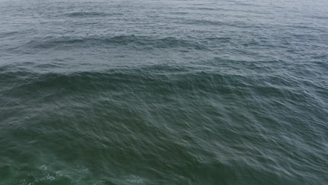 Open-water-of-the-Pacific-Ocean-gently-rolling,-aerial-view,-looping-background