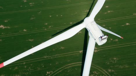 Filmische-Luftaufnahme-Einer-Großen-Windturbine,-Die-Saubere,-Nachhaltige-Energie-Erzeugt,-Grüner-Feldhintergrund