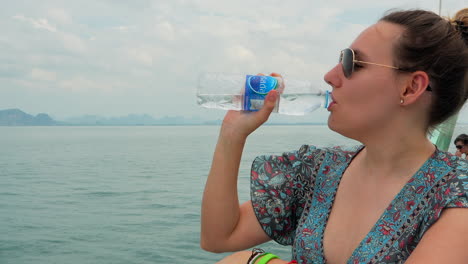 Posh-pretty-woman-drinking-mineral-water-on-a-ferry