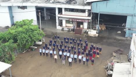 aerial-drone-view-The-drone-camera-is-moving-to-the-left-side-showing-both-the-outlet-of-a-large-factory-and-the-factory-and-at-the-entrance-of-the-factory-their-managers-supervisors