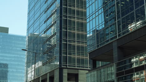 Modern-walls-are-made-of-glass-and-steel-with-reflections-of-buildings-and-blue-sky