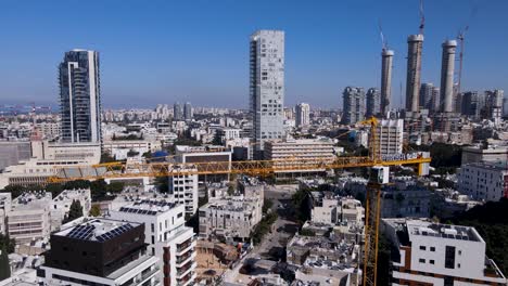 Yellow-High-crane-working-on-building-construction-on-David-Bloch-street,-Tel-Aviv,-Israel