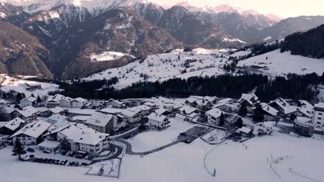 Ski-resort-town-Fiss-in-shadow-of-mountain,-aerial
