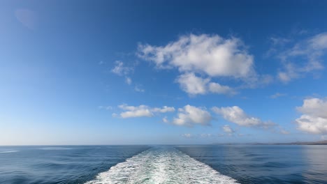 Waves-Coming-Off-Back-Side-Of-Boat,-Blue-Sky-Background,-Slow-Motion-Video