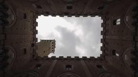 time-lapse-duomo-Siena,-Tuscany-Italy,-looking-up-with-medieval-decoration-framing-the-old-bell-tower-and-clouds-passed-by
