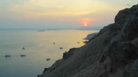 Boats-On-Sea-At-Sunset-By-The-Mountainous-Coast-On-Padar-Island-In-Indonesia