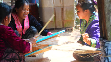 Thai-traditional-women-manually-weaving-together-and-smiling