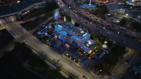 Aerial-view-around-the-illuminated-Downtown-Aquarium,-evening-in-Houston,-USA