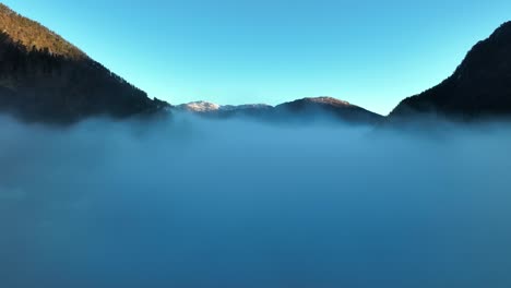 Flying-through-morning-haze-at-sunrise,-revealing-Kallestad-bridge-in-Stamnes-Norway