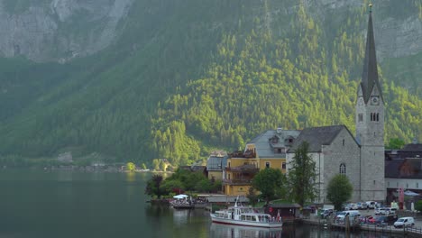 Ferry-Waits-for-Passengers-to-Board-in-Hallstatt-Village-Pier-near-Church