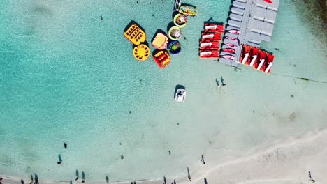 Rotierende-Draufsicht-Auf-Die-Nissi-Beach-Bay-Voller-Touristen,-Ayia-Napa,-Zypern