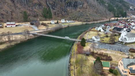 Weißer-Kleinbus-überquert-Kleine-Hängebrücke-über-Den-Fluss-In-Modalen,-Norwegen