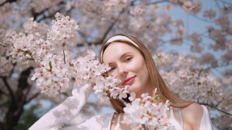 Joven-Caucásica-Sonriendo-Y-Posando-Con-Flores-De-Cerezo-En-Flor-En-El-Bosque-De-Ciudadanos-Yangjae,-Seocho,-Seúl,-Corea-Del-Sur