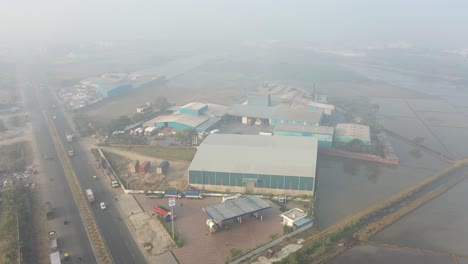 aerial-drone-view-The-drone-camera-is-moving-backwards-showing-the-large-fields-behind-the-factory-and-the-solar-panels-in-a-large-garden