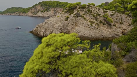 Kalamota-Island,-Adriatic-Sea,-Croatia---Travelers-Aboard-a-Sailboat,-Discovering-the-Crystal-clear-Blue-Waters-Near-the-Steep-and-Rugged-Cliffs---Drone-Flying-Forward