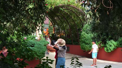 Turistas-Que-Visitan-La-Atracción-Histórica,-El-Invernadero-De-Cristal-Más-Grande-Del-Mundo-Con-Cúpula-De-Flores-En-Los-Jardines-Junto-A-La-Bahía,-Gente-Caminando-Hacia-El-Jardín-Mediterráneo