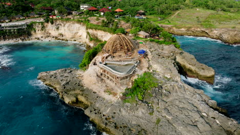 New-building-under-construction-on-rocky-cliff-of-Blue-Lagoon-Nusa-Ceningan,-Lembongan,-Bali-in-Indonesia