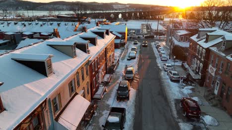 American-city-street-lined-with-row-houses-covered-in-snow-during-winter-sunset