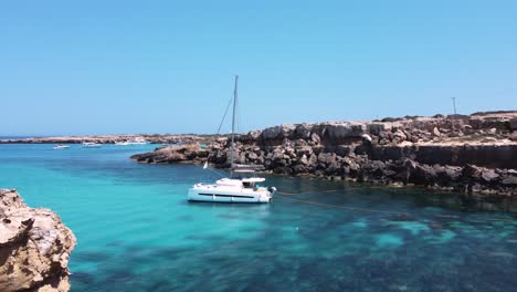 Revealing-Anchored-Catamaran-in-Idyllic-Crystal-Clear-Waters,-Ayia-Napa,-Cyprus