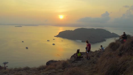 Menschen-Beobachten-Den-Sonnenuntergang-Von-Der-Bergigen-Küste-Auf-Der-Insel-Padar-In-Indonesien