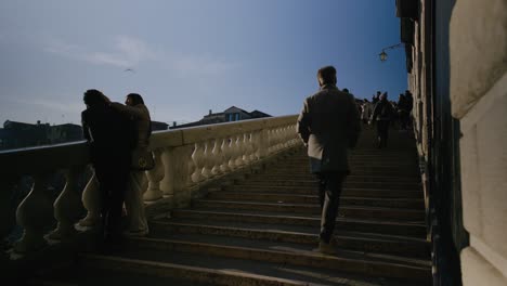 Couples-and-tourists-on-Rialto-Bridge-steps,-Venice-Italy