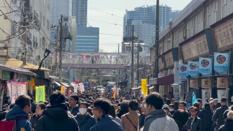 Multitud-De-Personas-Caminando-Entre-Rascacielos-En-El-Mercado-De-Pescado-De-Tsukiji,-Tokio,-Japón