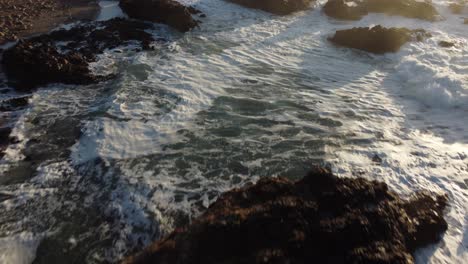 Low-Angle-Drone-Shot-of-the-Waves-along-Pescadero-State-Beach