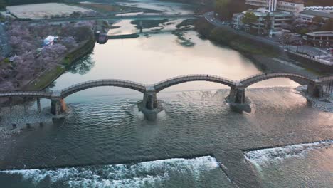 Vista-Aérea-De-Iwakuni-En-Primavera,-Puente-Kintaikyo-Al-Amanecer-En-La-Temporada-De-Sakura