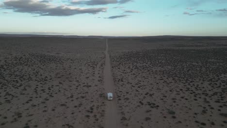 Una-Vista-Aérea-Captura-Una-Camioneta-Blanca-Que-Atraviesa-El-Terreno-Desértico,-Ubicado-Al-Sur-De-Salt-Lake-City,-Utah,-EE.UU.